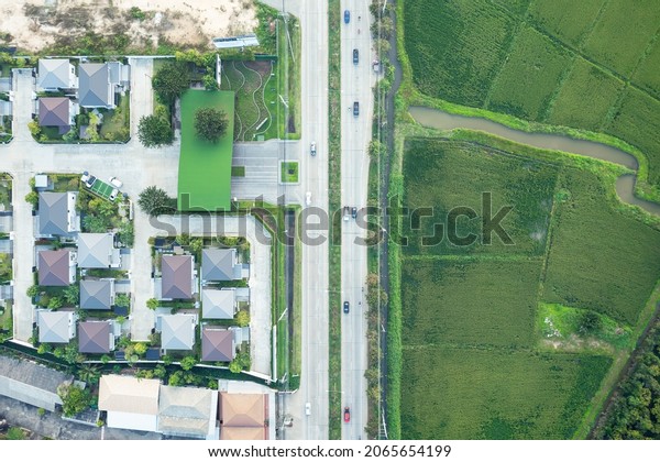 Housing estate and road in aerial view.\
Village or community with residential building in land lot. Real\
estate or property from development, construction for owned, sale,\
buy, mortgage or\
investment.