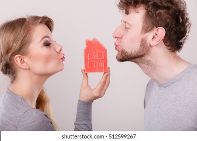 Housing Family Love Romance Future Concept. Couple Share Kisses With House Symbol. Young Married Man Lady Blow Kiss With Home Model.