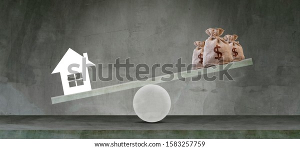 Housing loan\
market Sample houses and balance piggy bank on the seesaw Real\
estate concepts,Personal income\
imbalance.