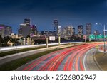 Houston downtown with car vehicle light tail on highway traffic to downtown district at night with skyscraper modern business office in Houston city in Texas, USA, United States of America at night