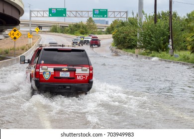 Houston, Texas - August 27, 2017: Houston emergency services cars across the flooded feeder street in Houston, Texas, USA. Heavy rains from hurricane Harvey caused many flooded areas in Houston.