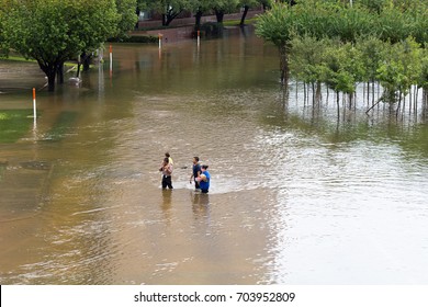 Houston, Texas - August 27, 2017: Houston residents walk across the flooded street in Houston, Texas, USA. Heavy rains from hurricane Harvey caused many flooded areas in Houston.