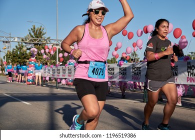 Houston, Texas - October 6, 2018:  Susan G. Komen Race For The Cure - Two Women Running To The Finish Line As  Volunteers Cheering On At The End Of The Race To Raise Money For Cancer Research