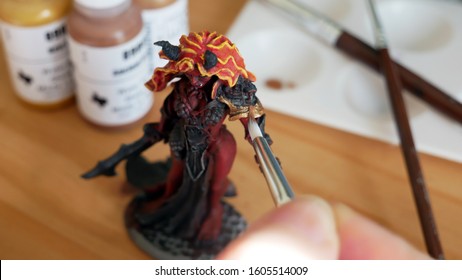Houston, Texas / USA - January 3, 2020: Miniature Painting a Fire Giant Mini Figure for D&D Tabletop Gaming