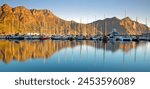 Hout Bay Harbour with yachts moored under the backdrop of Chapmansd Peak - Cape Town, South Africa