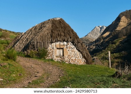 Hovel in the mountain in a sunny day with green grass and a blue sky