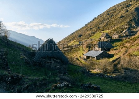 Hovels in the mountain in a sunny day with green grass and a blue sky