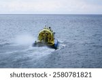 A hovercraft floats on the unfrozen Lake Baikal. Rear view. Khivus is a vehicle for moving on ice and water. An amphibious boat.