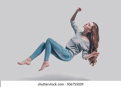 Hovering Beauty. Full Length Studio Shot Of Attractive Young Woman Hovering In Air And Keeping Eyes Closed