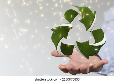 A hovering gree recycle icon on a man's hand against a blurred background