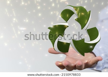 A hovering gree recycle icon on a man's hand against a blurred background