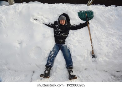 How To Avoid Heart And Back Pain While Shoveling Snow. A Man Is Resting On A Huge Pile Of Snow With A Snow Shovel After Shoveling, Removing A Lot Of Snow In The Backyard Of The House And A Sidewalk. 