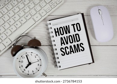 How To Avoid Scams text with alarm clock, keyboard and wireless mouse on wooden background