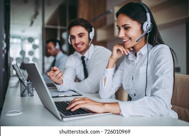 How can I help you? Beautiful call center workers in headphones are working at modern office. - Powered by Shutterstock