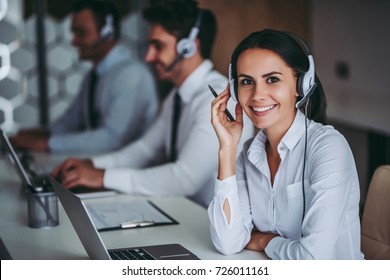 How Can I Help You? Beautiful Call Center Workers In Headphones Are Working At Modern Office.