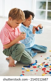 How Do These Pieces Fit Together. Two Cute Young Boys Playing With Building Blocks On The Flor.