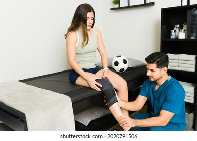 How Do You Feel? Professional Physiotherapist With A Leg Brace Checking The Knee Injury Of A Soccer Player