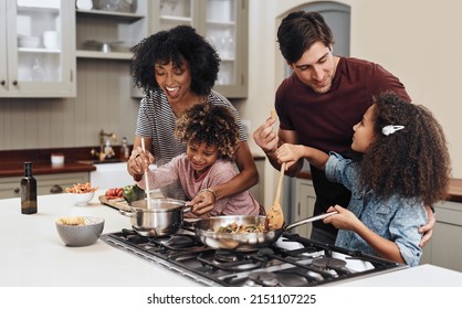 How does it taste Dad. Shot of a family of four cooking together in their kitchen at home. - Powered by Shutterstock