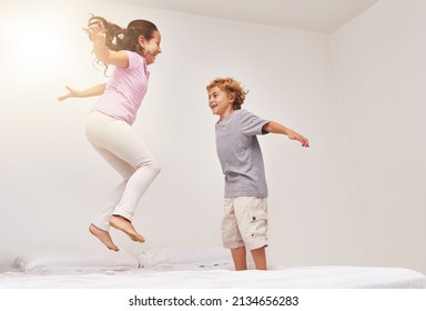 How High Can You Go. Shot Of Two Little Children Jumping On A Bed.