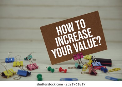 How To Increase Your Value? text on paper card with stationary on wooden background