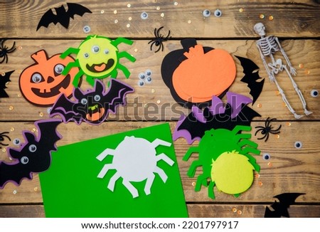 How to make a decor for congratulations and fun on Halloween. Women's hands make crafts from felt and other materials. A green spider for Halloween. Handmade toys.Step 1. Circle the paper stencil.