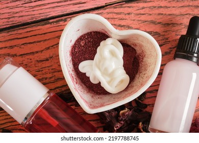 How To Make Face Mask Based On Hibiscus Step By Step, DIY Natural Cosmetics Concept, Face Mask From Hibiscus Cream And Powder In Bowl, Spray Lotion And Serum With Hibiscus Extract On Wooden Background