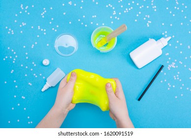 How To Make Mucus At Home. Children's Art Project. DIY Concept. Children's Hands Making Slime Toy On Blue. Step By Step Photo Instruction