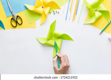 How To Make Paper Green Windmill Toy With Children At Home. Step By Step Instructions. Hands Making DIY Summer Project. Step 9. Mark Center Of Resulting Figure, Capturing All The Edges Of Triangles