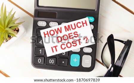 How Much Does it Cost write on sticky note isolated on wooden table.
