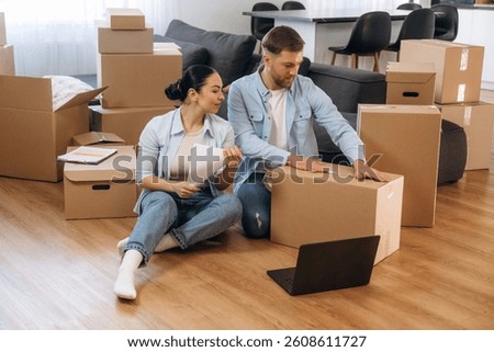 How to pack the box using scotch tape. Happy couple moved into new house.