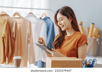 How To Start A Clothing Store Online Business apparel! Young confident asian female fashion owner social media influencer Live selling clothes, new products at home office small business e-commerce.