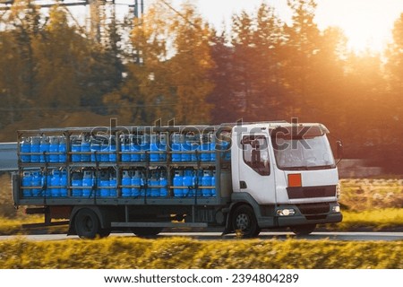 How to Transport LPG Gas Safely and Efficiently. A Vehicle with a Container of Flammable and Combustible Cylinders on the Road. Blue steel gas cylinders Foto stock © 
