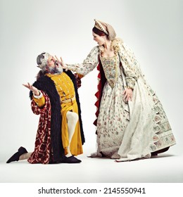 How Very Dare You. Studio Shot Of A Queen Slapping A Kneeling King In The Face.