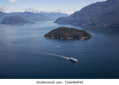 Howe Sound, Vancouver, BC, Canada - July 21, 2018: Aerial view of BC Ferry traveling in the ocean during a vibrant sunny summer day.