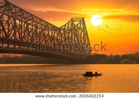 Howrah bridge with fishing boat on river Ganges at sunrise at Kolkata India
