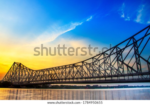Howrah bridge - The historic cantilever\
bridge on the river Hooghly in West Bengal with twilight sky.\
Beautiful sunset view with blue sky and\
clouds.