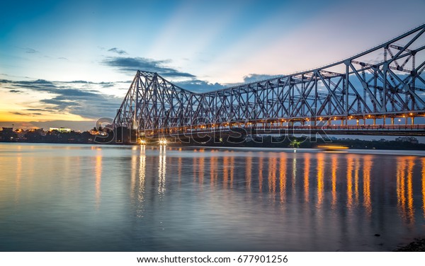 Howrah bridge - The historic cantilever bridge on\
the river Hooghly with twilight sky. Howrah bridge is considered as\
the busiest bridge in\
India.