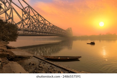 Howrah bridge with wooden boats on the Ganges river at sunrise at Kolkata, India.  - Powered by Shutterstock