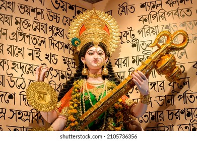 Howrah, West Bengal, India - 17th February 2021 : Idol of Goddess Saraswati being worshipped inside pandal , a temporary temple, at night. Bengali poems are written as decoration.