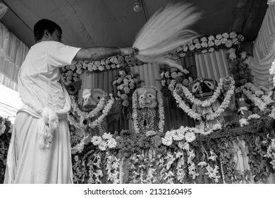 Howrah, West Bengal, India - 7th July 2019 : Hindu priest worshipping idol of God Jagannath, Balaram and Suvodra with chamor. a kind of fan. Ratha jatra festival is festival in India. Black and white.