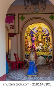 Howrah,India -October 26th,2020 : Bengali Girl Child Posing With Goddess Durga In Background, Inside Old Age Decorated Home. Durga Puja, Biggest Festival Of Hinduism, UNESCO Heritage Of Humanity.