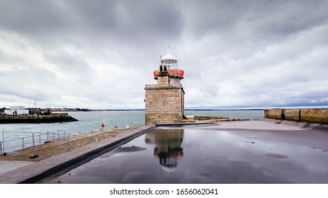 Howth Lighthouse reflected in water. Cloudy weather Howth harbour, Dublin, Ireland