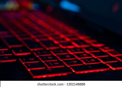 HP omen keyboard with red back lit keys with a shallow depth of field - Shutterstock ID 1302148888