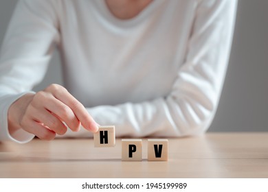 HPV (Human Papillomavirus) acronym on wood block, Asian woman  holding wooden block, viruses Some strains infect genitals and can cause cervical cancer. Women health concept.