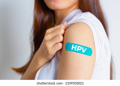 HPV (Human Papillomavirus) Teenager woman showing off an blue bandage after receiving the HPV vaccine.viruses Some strains infect genitals and can cause cervical cancer. Woman health concept. 