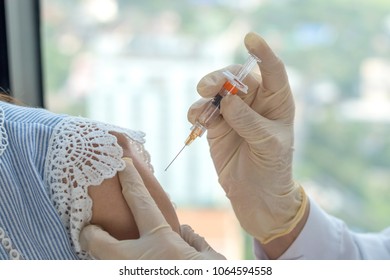 HPV Vaccine Healthcare Concept. Hand Of Medical Nurse Or Doctor Holding Medical Syringe Giving A Shot To Woman's Arm In Hospital. International HPV Awareness Day