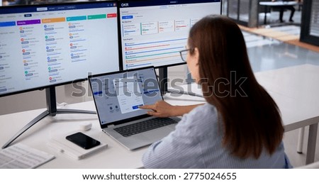 HR Manager Checks Payroll Data On Multiple Screens To Ensure Accuracy.