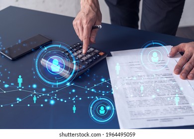 HR specialist researching and analyzing the data of salary on employment market to forecast ongoing expenses of the company using calculator. Hiring new talented officers. Social media hologram icons - Powered by Shutterstock