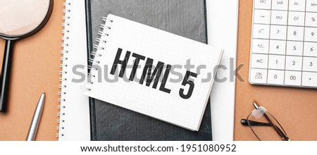 html 5 on notepad and various business papers on brown background. Brown glasses and magnifier with notepad.