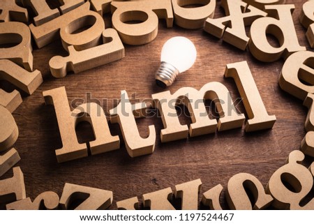 HTML abbreviation (Hypertext Markup Language) in scattered wood letters with glowing white light bulb